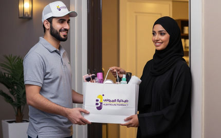 A delivery man hands a shopping bag of beauty products to a smiling Gulf woman.