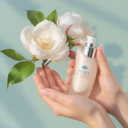 Intimate health care product held in hands with a white flower in the background